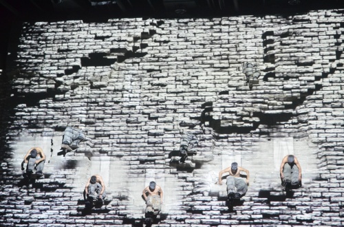 The dancers are performing on the wall surface.