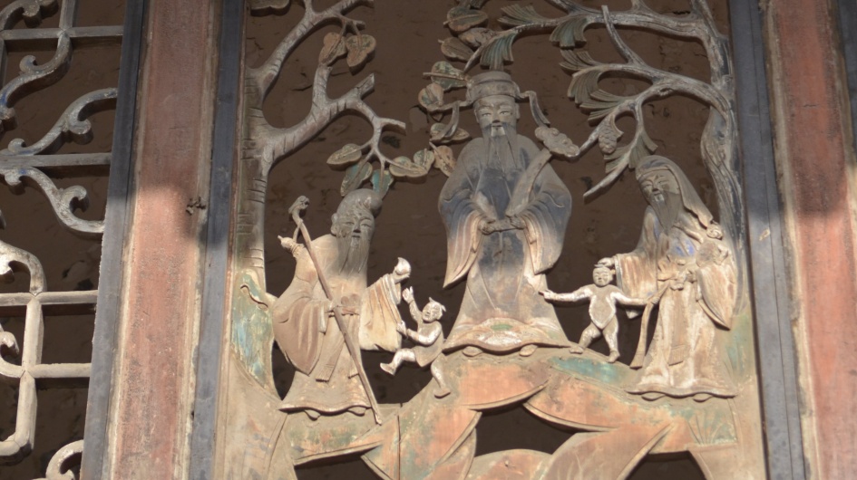 The exquisite carvings of figures on the wooden windows of the Wang Family Compound.